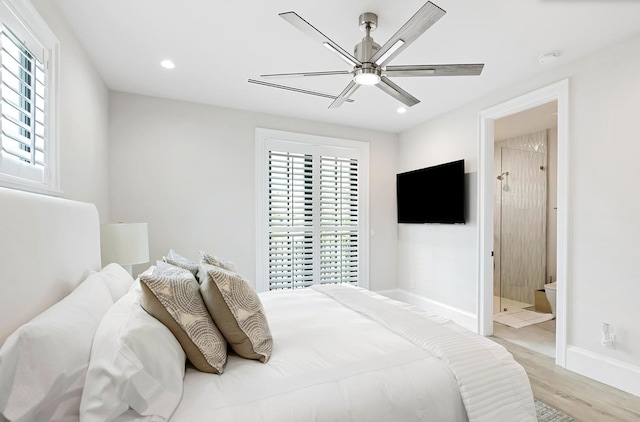 bedroom featuring light hardwood / wood-style floors, ensuite bath, and ceiling fan