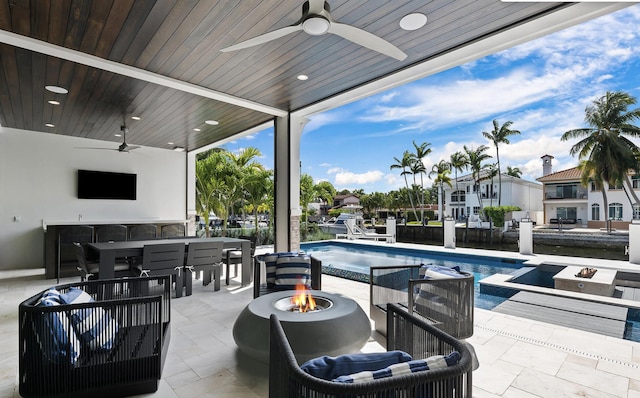 view of patio with an outdoor bar, an outdoor fire pit, and ceiling fan