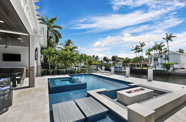 view of swimming pool featuring a patio area, a water view, an outdoor fire pit, and an in ground hot tub