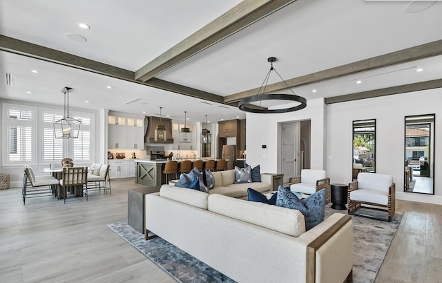 living room featuring beam ceiling and light hardwood / wood-style flooring