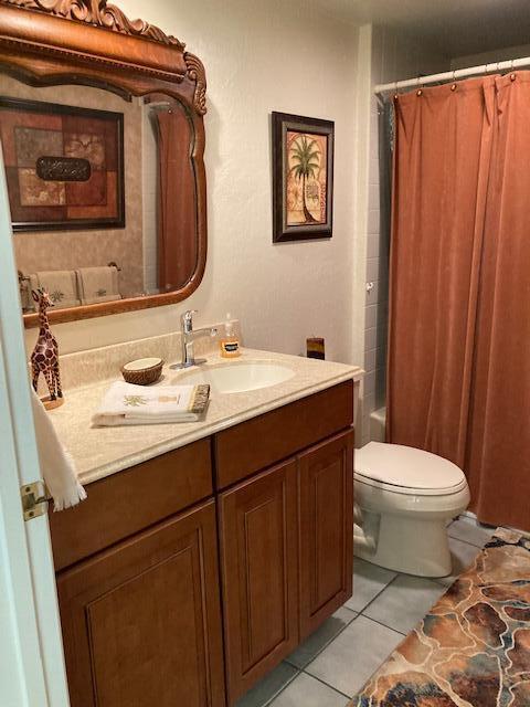 full bathroom with tile patterned flooring, vanity, toilet, and shower / tub combo