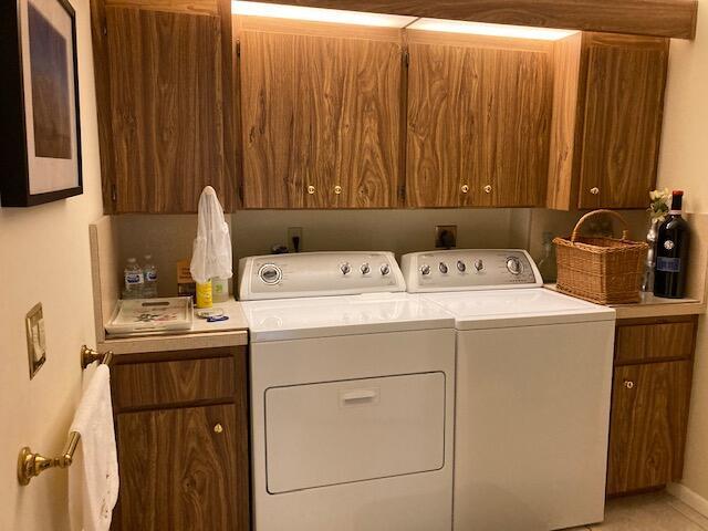 clothes washing area featuring cabinets and independent washer and dryer