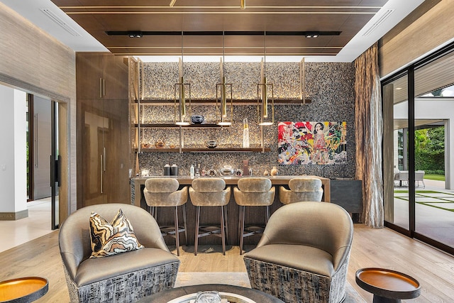 bar featuring light wood-type flooring and wet bar