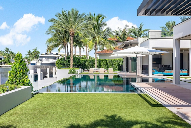 view of swimming pool featuring a yard, a patio area, and a fenced in pool