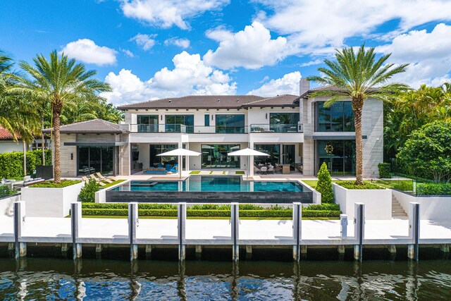 rear view of house featuring a water view and a patio