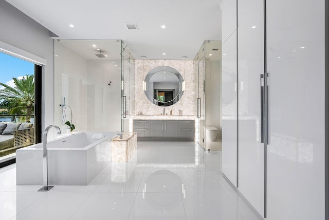 bathroom featuring a stall shower, visible vents, tile patterned flooring, vanity, and a freestanding tub