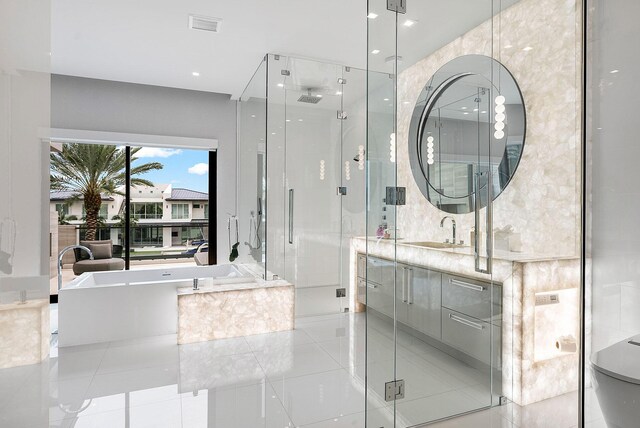 bathroom featuring shower with separate bathtub, vanity, tile patterned floors, and tile walls