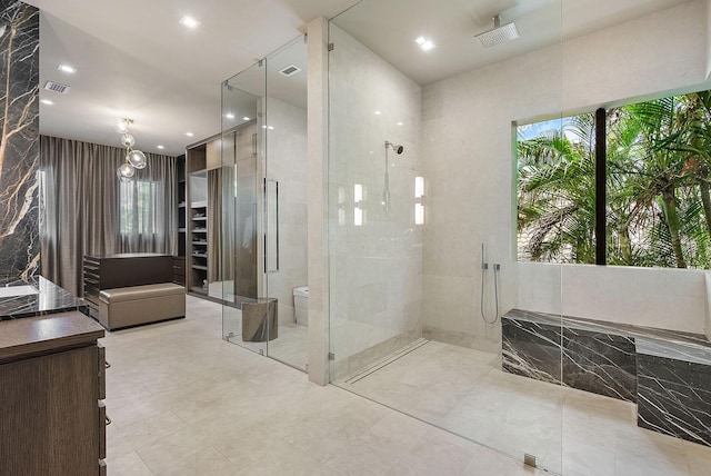 bathroom with a stall shower, visible vents, and a spacious closet