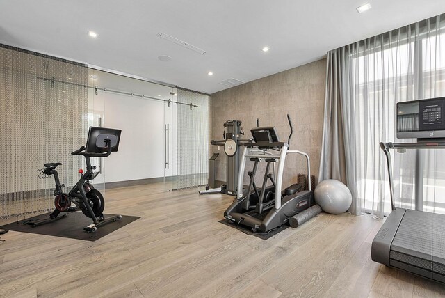 workout room featuring light hardwood / wood-style flooring and expansive windows