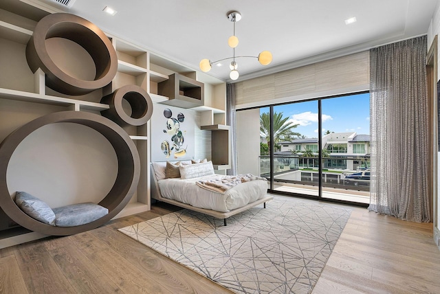 bedroom featuring access to exterior, light wood-style flooring, and expansive windows