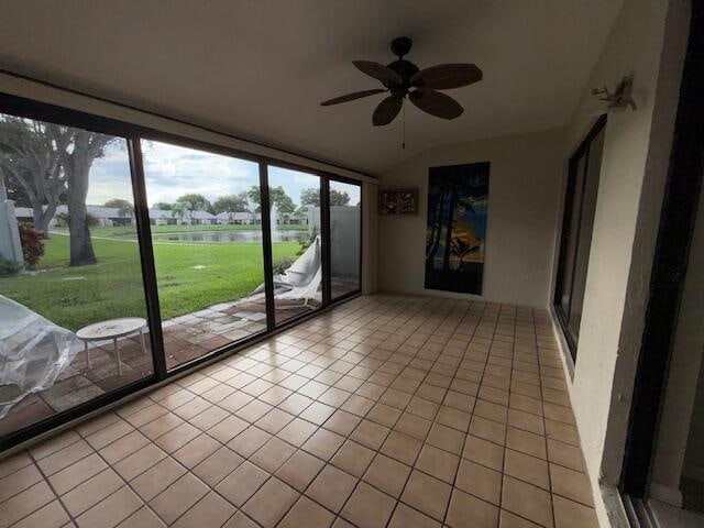 unfurnished sunroom featuring ceiling fan and vaulted ceiling