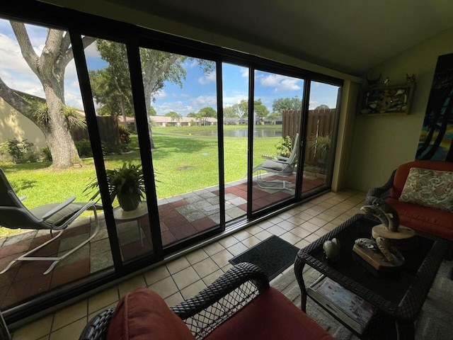 interior space featuring lofted ceiling, light tile patterned floors, and a water view