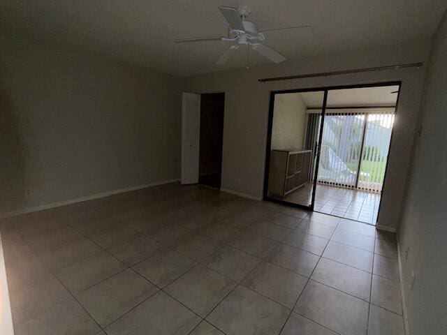 tiled spare room featuring ceiling fan