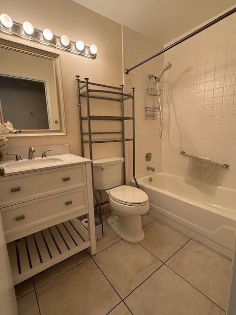 full bathroom featuring vanity, tile patterned floors, toilet, and tiled shower / bath combo