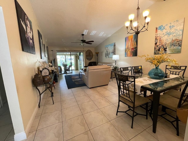 tiled dining area featuring ceiling fan with notable chandelier, a textured ceiling, and vaulted ceiling