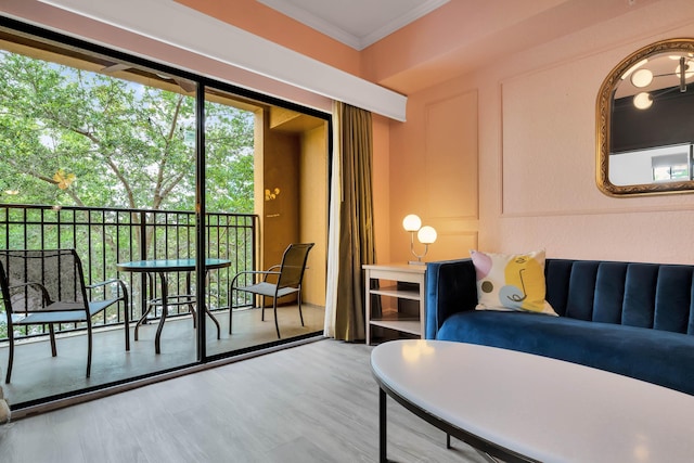 bedroom with access to outside, ornamental molding, and wood finished floors