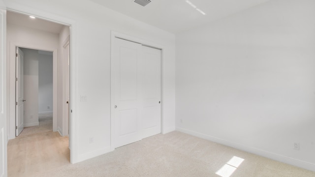 unfurnished bedroom featuring light carpet