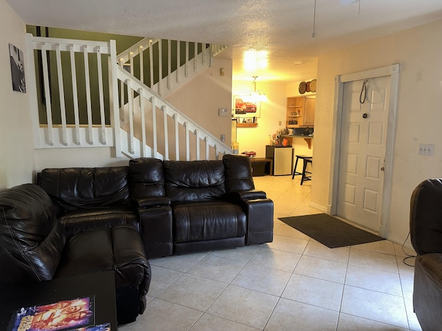 tiled living room featuring stairway and a chandelier