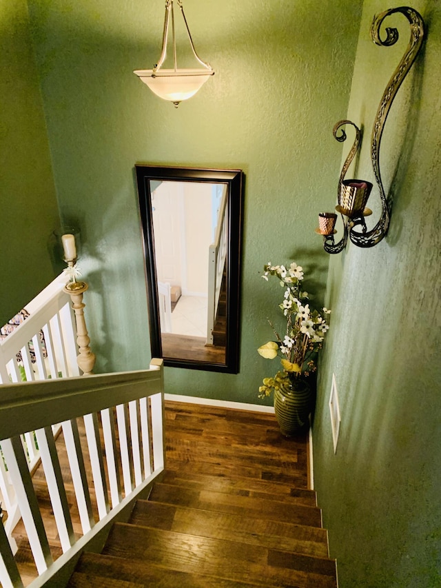 stairway featuring wood finished floors and baseboards