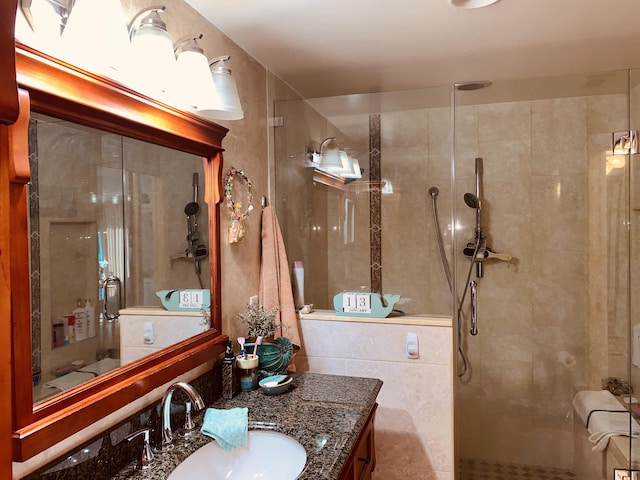 full bathroom featuring tiled shower and vanity