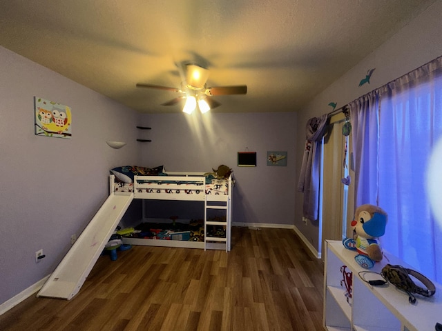 bedroom featuring wood finished floors, baseboards, and a ceiling fan