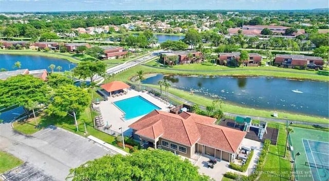 drone / aerial view of a nearby body of water and a pool area