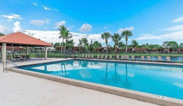 community pool with a gazebo and fence