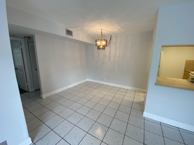 spare room featuring a chandelier