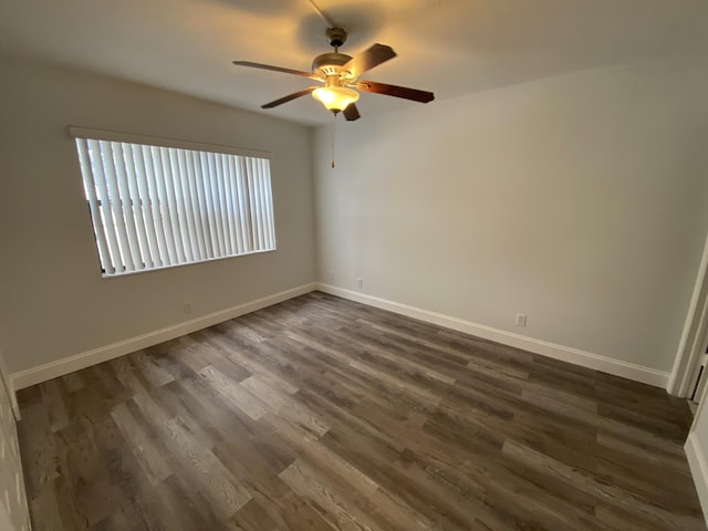 spare room featuring ceiling fan and dark wood-type flooring