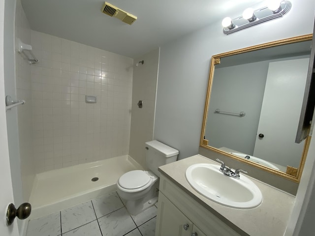 bathroom featuring tiled shower, vanity, and toilet