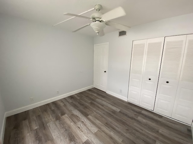 unfurnished bedroom featuring a closet, ceiling fan, and dark wood-type flooring