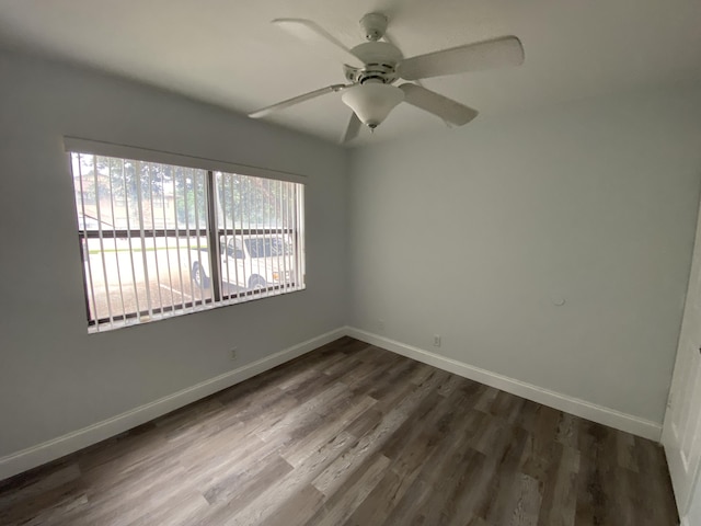 empty room with ceiling fan and dark hardwood / wood-style flooring