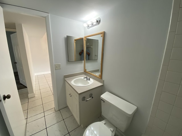 bathroom featuring tile patterned flooring, vanity, and toilet