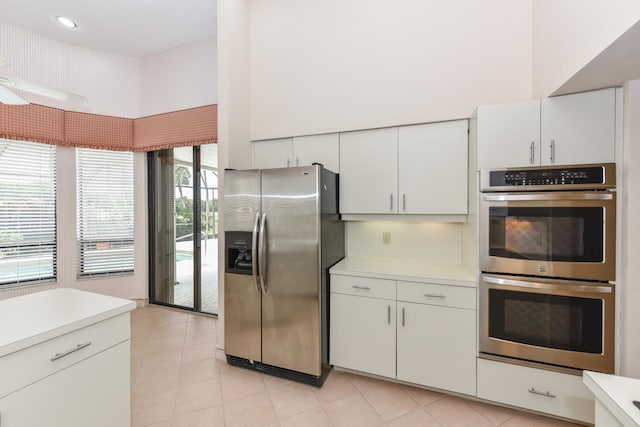 kitchen with white cabinets, light tile patterned floors, and appliances with stainless steel finishes