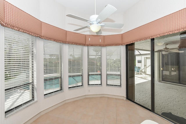 unfurnished sunroom featuring ceiling fan