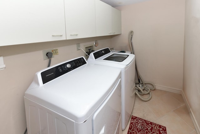 laundry room featuring cabinets, separate washer and dryer, and light tile patterned floors