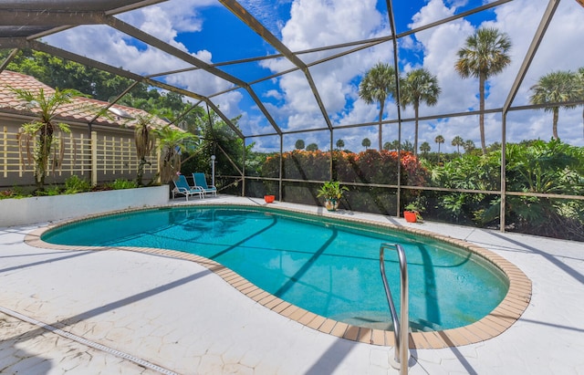 view of swimming pool featuring glass enclosure and a patio area