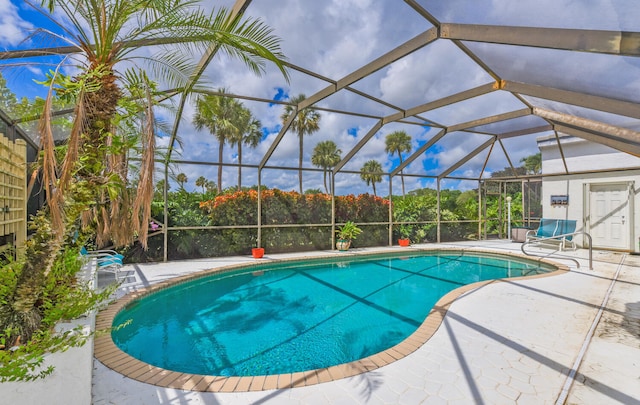 view of pool featuring glass enclosure and a patio area