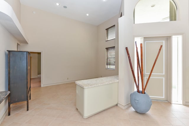 tiled entrance foyer featuring a towering ceiling