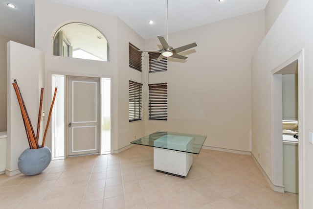 tiled foyer entrance featuring ceiling fan and high vaulted ceiling