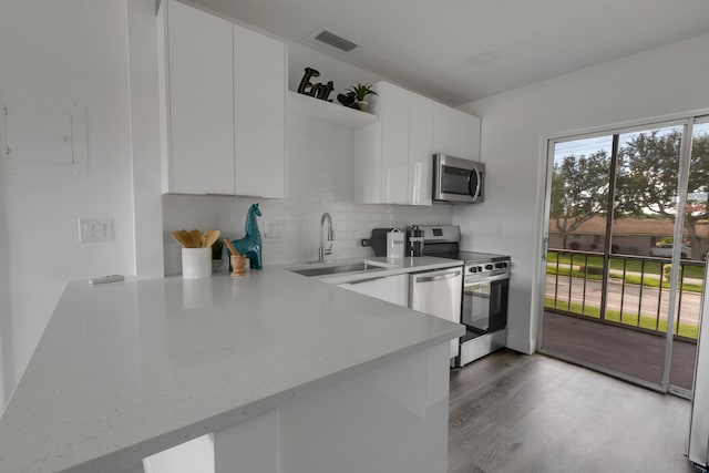 kitchen featuring stainless steel appliances, tasteful backsplash, sink, and white cabinets