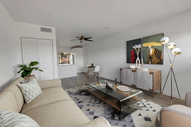 living room featuring wood-type flooring and ceiling fan