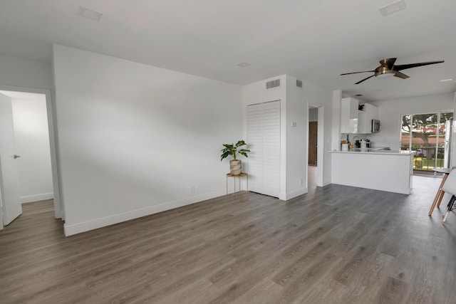 unfurnished living room featuring ceiling fan and dark hardwood / wood-style floors