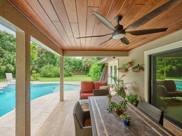 view of swimming pool with outdoor lounge area, ceiling fan, and a patio area