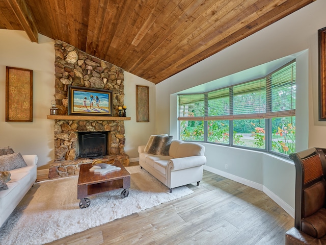 living room featuring wood ceiling, a fireplace, light wood-type flooring, and vaulted ceiling