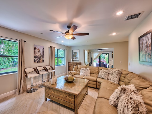 tiled living room with ceiling fan