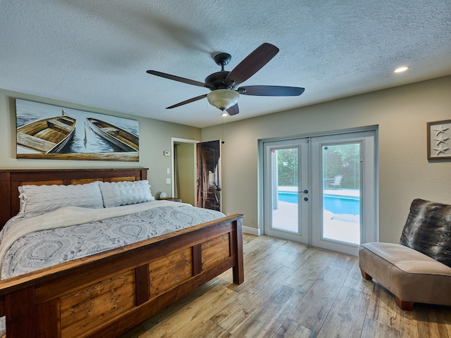 bedroom featuring french doors, light hardwood / wood-style flooring, a textured ceiling, access to exterior, and ceiling fan