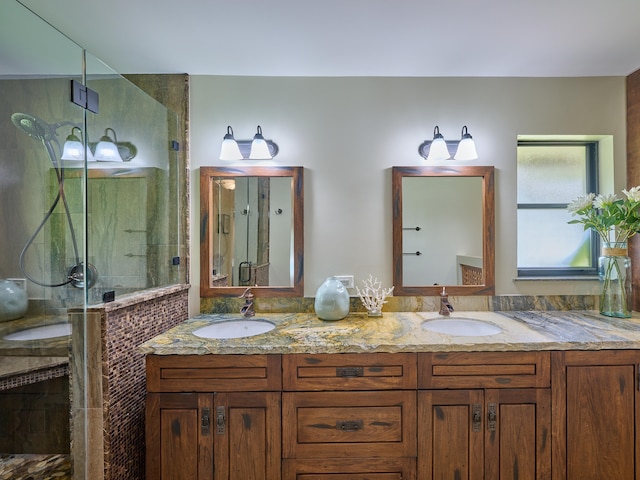 bathroom with dual vanity and a shower with shower door