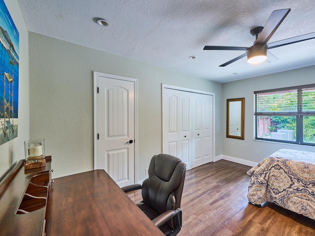 bedroom with a textured ceiling, hardwood / wood-style floors, and ceiling fan