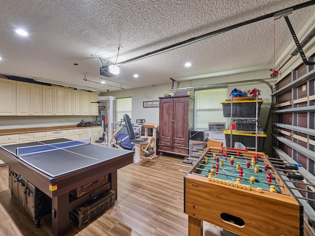 game room featuring light hardwood / wood-style flooring and a textured ceiling